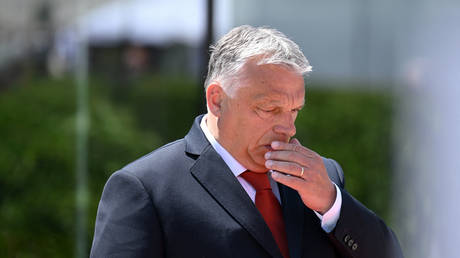 Hungary's Prime Minister Viktor Orban covers his mouth as he arrives at the European Political Community (EPC) Summit in Bulboaca, on June 1, 2023.