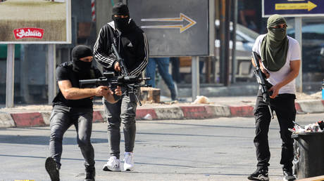Palestinian armed militants take up position during a confrontation with Israeli army in the occupied West Bank city of Jenin on July 3, 2023