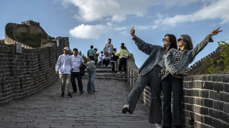 FILE PHOTO:  Two women take photos on the Great Wall during the Labour Day holidays, April 29, 2023