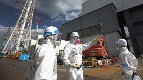 Workers stand outside reactor 4 as they continue the radiation decontamination process at the Tokyo Electric Power Co.'s embattled Fukushima Daiichi nuclear power plant on February 25, 2016 in Okuma, Japan