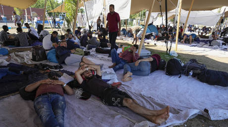 FILE PHOTO: Migrants seek shelter outside an overcrowded asylum seekers center in Ter Apel, northern Netherlands, August 25, 2022