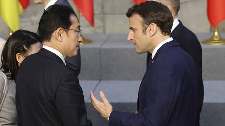 FILE PHOTO: French President Emmanuel Macron speaks with Japanese PM Fumio Kishida at NATO headquarters in Brussels, March 24, 2022