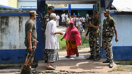 Paramilitary personnel stand guard at the entrance of a polling station during West Bengal's 'Panchayat' or local elections, on the outskirts of Kolkata on July 8, 2023.