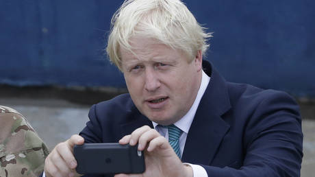 FILE PHOTO: Then-UK Foreign Secretary Boris Johnson takes a photo during a visit to the naval dockyard in Lagos, Nigeria, August 31, 2017.