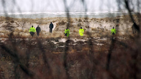 Suffolk County Police and police recruits search an area of beach near where police recently found human remains on April 5, 2011 in Babylon, New York