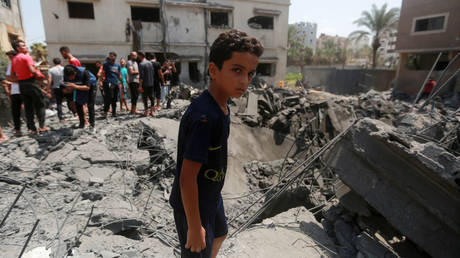 Palestinians inspect the rubble following an August 2022 Israeli airstrike on a residential building in Gaza City.