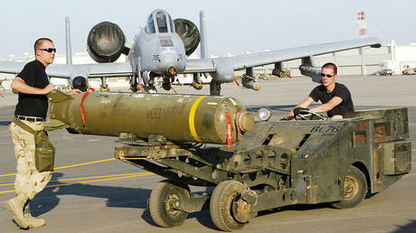 FILE PHOTO: US troops move a cluster bomb onto an A-10 Warthog jet at an Arabian Gulf base near the Iraq border in March 2003.