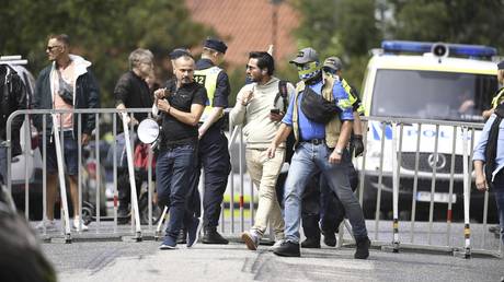 Protestor Salwan Momika is escorted by police to a location outside the Iraqi embassy in Stockholm, July 20, 2023