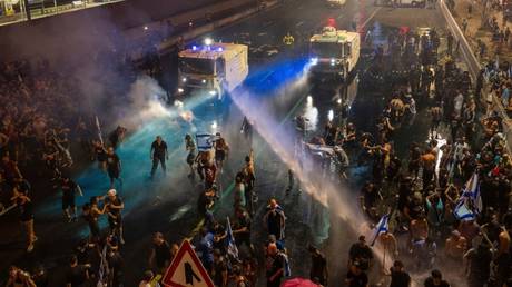 Riot police attempt to clear demonstrators with a water canon during a protest against new judicial reforms, in Tel Aviv, Israel, July 24, 2023.