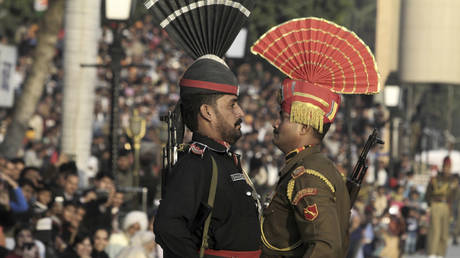 FILE PHOTO. A Pakistani Ranger in black uniform and his Indian counterpart, march during a flag off ceremony, at the joint Pakistan-India border check post of Wagah near Lahore, Pakistan.