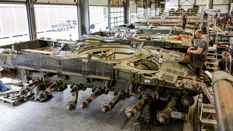 Technicians assemble a Leopard 2 tank that gets maintenance at the facility of Rheinmetall in Unterluess, northern Germany.