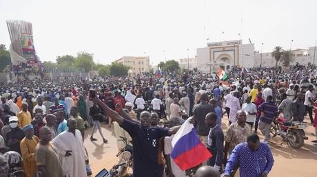 FILE PHOTO: Nigeriens, some holding Russian flags, participate in a march called by supporters of coup leader Gen. Abdourahmane Tchiani in Niamey, Niger, July 30, 2023