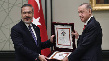 Turkish President Recep Tayyip Erdogan (R) presents a gift to the Turkish Foreign Minister Hakan Fidan (L) during a meeting of the National Security Council (MGK) in Ankara, Turkiye on August 9, 2023.