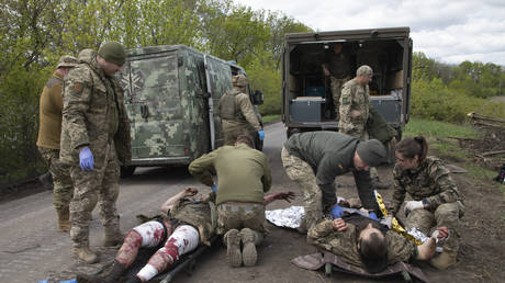 Military medics give first aid to wounded Ukrainian soldiers on the road near Artyomovsk, Donetsk region, May 11, 2023