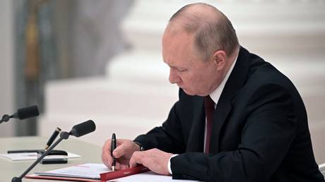 FILE PHOTO: Vladimir Putin signs documents during a ceremony at the Kremlin in Moscow, Russia, February 21, 2022