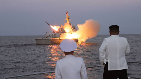 North Korean leader Kim Jong-un (R) oversees the launch of a cruise missile from a warship in the Sea of Japan, on August 21, 2023.