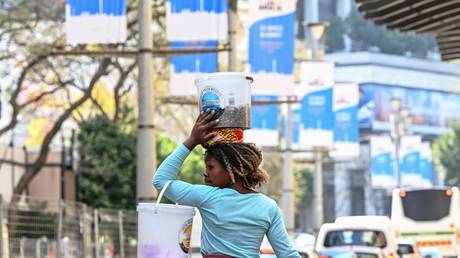 A young woman walks in a street near the Sandton Convention Centre, which will host the upcoming BRICS Summit, in Johannesburg, South Africa.