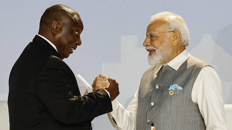 South African President Cyril Ramaphosa (L) and Prime Minister of India Narendra Modi (R) shake hands during the 2023 BRICS Summit in Johannesburg on August 24, 2023.