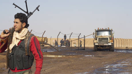 FILE PHOTO: A Syrian rebel stands guard at an oil well near Shahel, Syria.