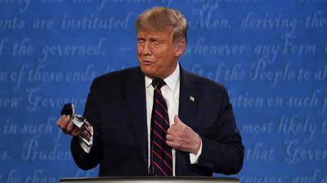Donald Trump looks at his face mask during a first presidential debate in Cleveland, Ohio, September 29, 2020