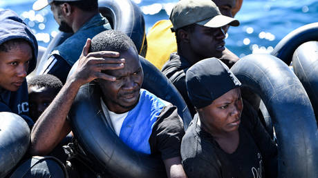 Migrants of African origin trying to flee to Europe are crammed on board of a small boat, as Tunisian coast guards prepare to transfer them onto their vessel, at sea between Tunisia and Italy, on August 10, 2023.