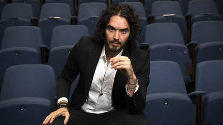 Russell Brand poses for photographs as he arrives to deliver The Reading Agency Lecture at The Institute of Education on November 25, 2014 in London, England