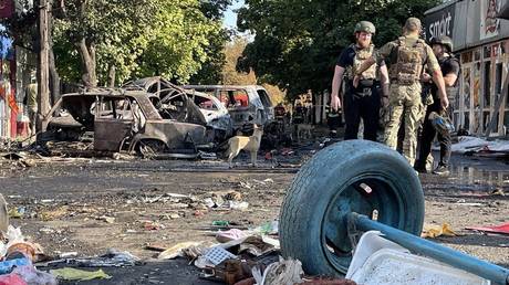 Ukrainian police and rescuers stand near wreckage following a missile strike in Konstantinovka