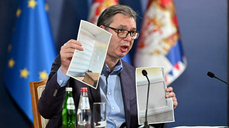 Serbia's President Aleksandar Vucic shows some photographs during a press conference in Belgrade on September 24, 2023.