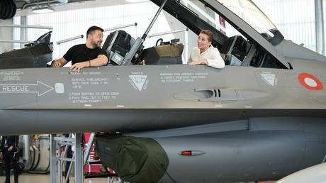 Ukrainian President Vladimir Zelensky (L) and Danish Prime Minister Mette Frederiksen (R) sit in a F-16 fighter jet on August 20, 2023