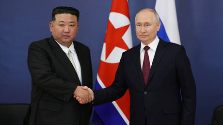 Russian President Vladimir Putin and North Korean leader Kim Jong Un shake hands during a meeting at the Vostochny Cosmodrome.