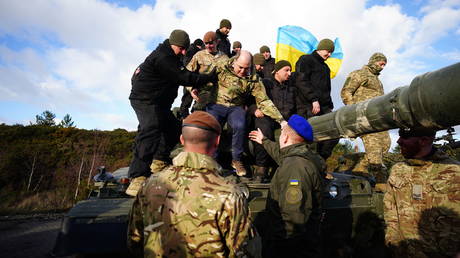 FILE PHOTO: Ben Wallace, then defense secretary, is helped off a tank during a visit to Bovington Camp to see Ukrainian soldiers training on the Challenger 2, February 22, 2023
