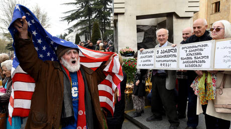 FILE PHOTO: A man holds a US flag during a rally on the Day of National Unity in Tbilisi, Georgia