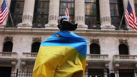 FILE PHOTO The Fearless Girl statue is seen draped in the flag of Ukraine in front of the New York Stock Exchange