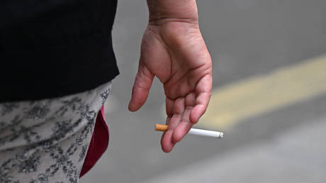 A man holds a cigarette in London, 2022.