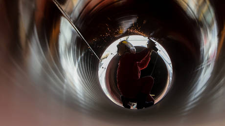 File photo of a worker performing construction on a natural gas pipeline in Hami City, Xinjiang Province, China, Nov. 24, 2022
