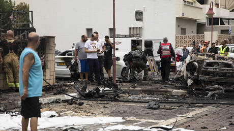 A man looks at a scene of burned cars after a rocket fired from the Gaza Strip landed in a street on October 9, 2023 in Ashdod, Israel.