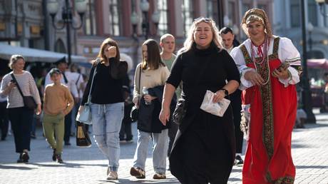 People walk along Arbat Street on a warm autumn day, in Moscow, Russia.