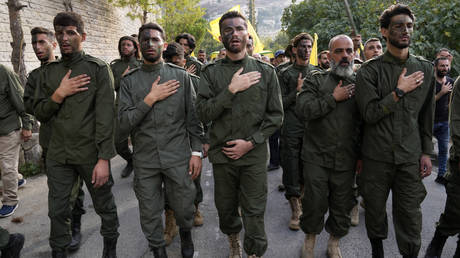 Hezbollah fighters mourn, as they attend the funeral procession of their two comrades who were killed by Israeli shelling, in Kherbet Selem village, south Lebanon, Tuesday, Oct. 10, 2023.