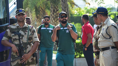 Pakistan's Shadab Khan (C) walks to board Pakistan's team bus amid security personnel upon landing at the airport in Ahmedabad on October 11, 2023, ahead of the 2023 ICC Men's Cricket World Cup one-day international (ODI) match between India and Pakistan.