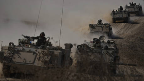 Israeli armored personnel carriers head toward the Gaza border in southern Israel, October 13, 2023.