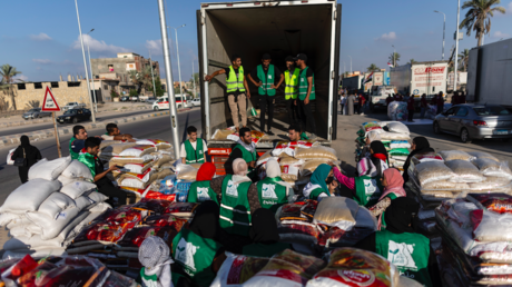 Volunteers load food and supplies onto trucks in an aid convoy for Gaza on October 16, 2023 in North Sinai, Egypt.