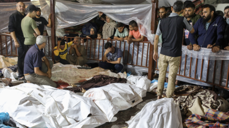 People gather around bodies of Palestinians killed in Israeli airstrikes on the Ahli Arab hospital in central Gaza on October 17, 2023. © Dawood Nemer / AFP