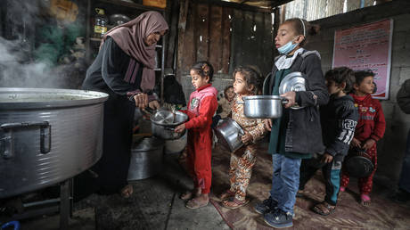 FILE PHOTO: Children gather to get food aid distributed by a benefactor woman to needy families at Zeitoun neighborhood in Gaza City, Gaza.