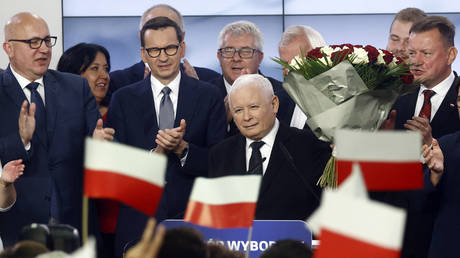 Polish Deputy Prime Minister and leader of the Law and Justice party (PiS) party, Jaroslaw Kaczynski (C) and Polish Prime Minister Mateusz Morawiecki (3L) of the Law and Justice party react with supporters at the party's headquarters in Warsaw, Poland on October 15, 2023.