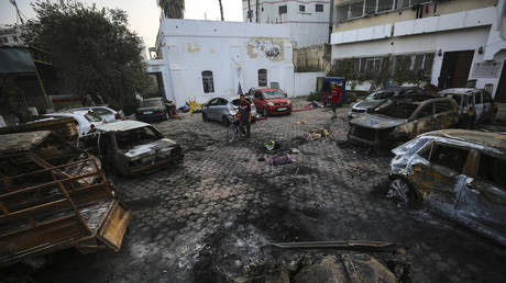 Palestinian men look over the site of a deadly explosion at al-Ahli Hospital in Gaza City, October 18, 2023