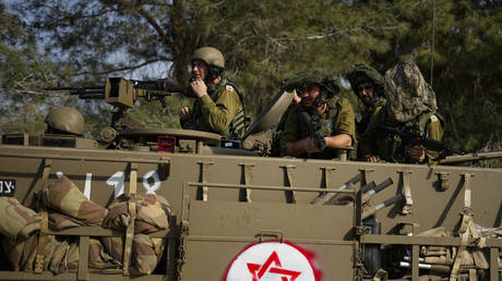 Israeli soldiers drive an armored personnel carrier near the border with Gaza in southern Israel, October 22, 2023