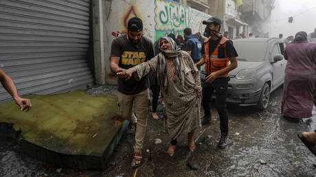 People help evacuate a Palestinian woman following Israeli airstrikes that targeted her neighborhood in Gaza City, Monday, Oct. 23, 2023.
