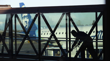 FILE PHOTO: A worker cleans a jet bridge before passengers board an Alaska Airlines flight, at the airport in Everett, Washington, March 4, 2019.