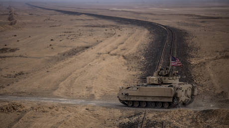 FILE PHOTO: American soldiers drive a Bradley fighting vehicle during a joint exercise with Syrian Democratic Forces in northeastern Syria, December 8, 2021