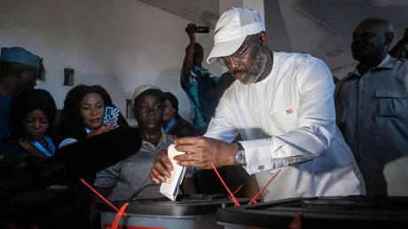 Liberia's Incumbent President George Weah casts his vote at a polling station in Monrovia on October 10, 2023 during the presidential vote.